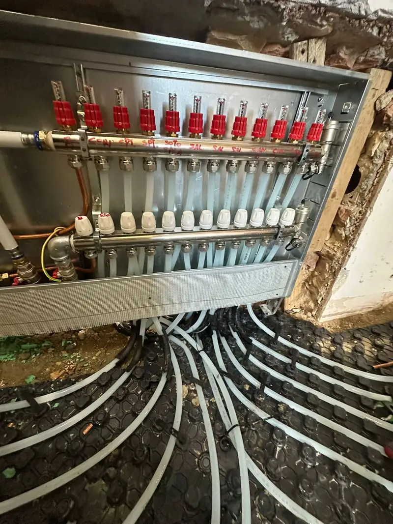 Collettore di distribuzione in acciaio inox a tredici derivazioni, con flussometri e circuiti del pavimento radiante.